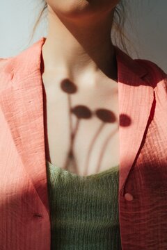 Anonymous female with shadow of flowers on chest
