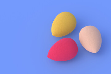 Egg sponges on blue background. Cosmetic accessories. Beauty and fashion. Makeup tools. Copy space. 3d render