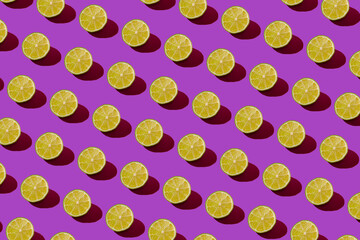 Lime pattern on a purple background. Pop art design, creative citruses. Yellow lemon, minimal flat style.