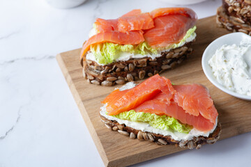Healthy toasts with rye bread with cream cheese, salmon and salad.