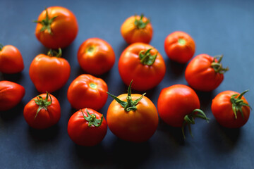 Fresh organic tomatoes, picked from the garden, on dark background. Selective focus.