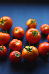 Fresh organic tomatoes, picked from the garden, on dark background. Selective focus.