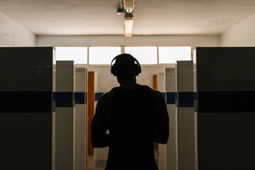 Anonymous sportsman listening to music in headphones
