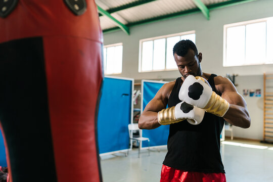 African American boxer putting on gloves
