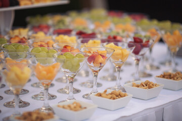 Obraz na płótnie Canvas Catering on wedding. Wedding banquet table. Sweet table with fruit. Fruit bar on party. Delicious fruits appetizers, desserts on stand, modern sweet tab.