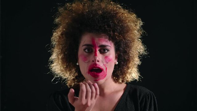 breakdown, crisis - lunatic woman draws her face with lipstick crying
