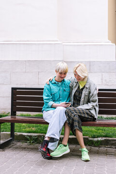 Women Browsing In Mobile Phone In Public Place During Meeting