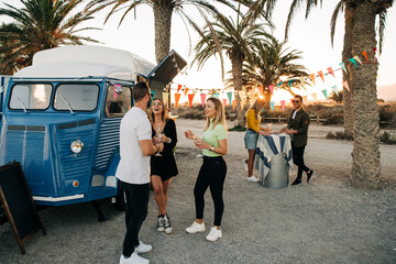 Happy friends chilling near food van