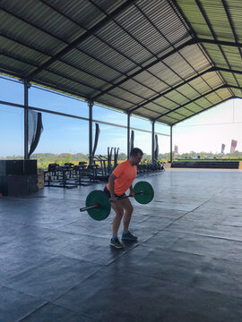 UGC, Man working out, doing barbel rows in an open gym, Bali,Indonesia