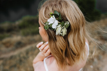 Naklejka premium Beautiful hairpin of flowers, peonies close-up on long hair, hairstyle of the bride, blonde. wedding photography.