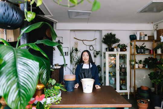 Professional flower employee working in spacious garden store