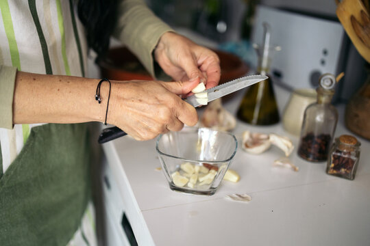 Woman cutting garlic in the kitchen