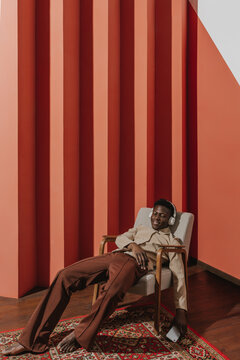 The guy relaxes and listens to music in a minimalistic interior.
