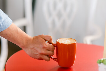 Hand catching coffee cup 