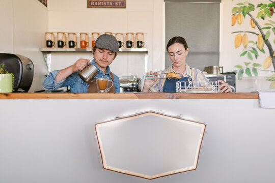 Baristas serving coffee and empanadas at Shop