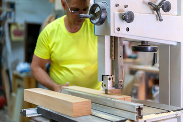 master carpenter adjusting his cutting machine in his workshop