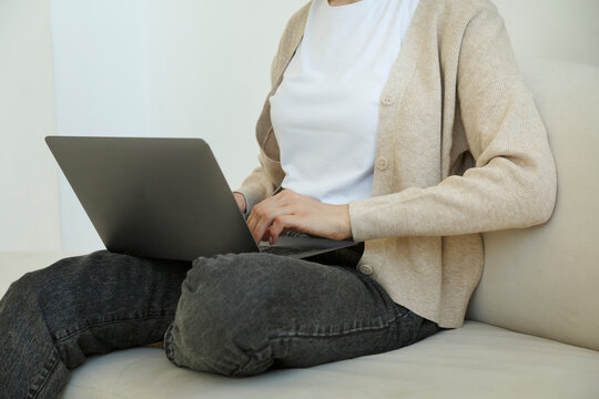 Crop female using netbook on couch
