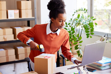Black employee entering parcel data into laptop