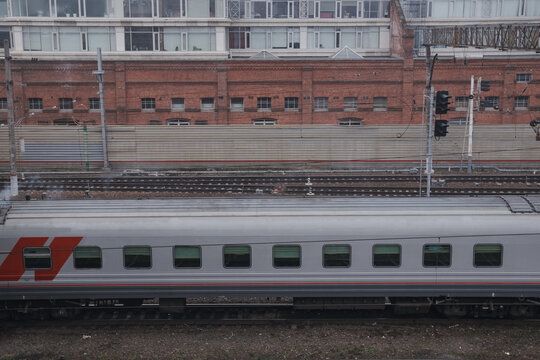 Train passing by a brick building.