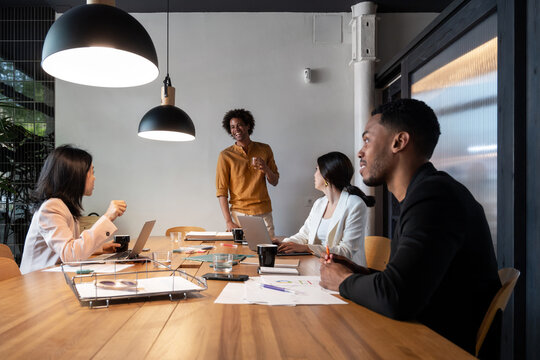 Diverse businesspeople listening to black colleague