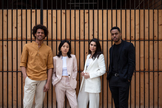 Confident business team against wooden wall