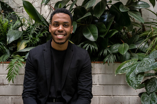 Cheerful black manager in indoor garden