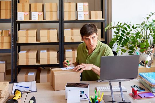 Serious logistic manager preparing parcel for shipping