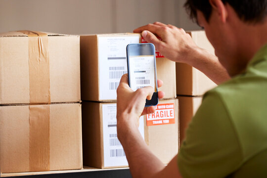 Man shooting sticker on box on shelf