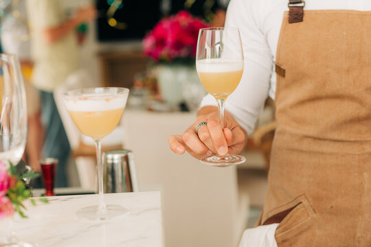Hand of a male barmen holding a cocktail