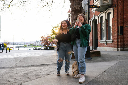 Two People Tkaing Photos With Cell Phones.