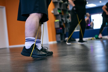 Man Using Cord To Stretch Legs In Class