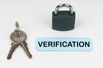 On a white surface there is a lock, keys and a blue sign with the inscription - Verification
