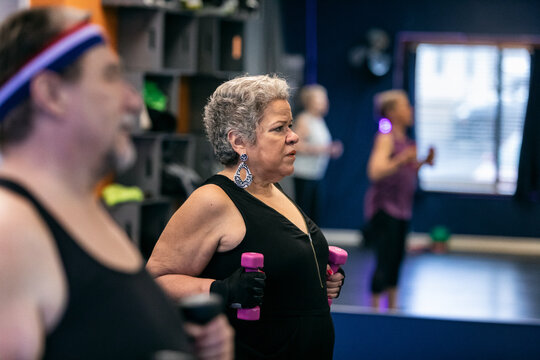 Senior Hispanic Woman Using Weights To Exercise