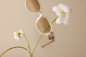 pair of sunglasses floating in scene with white flower