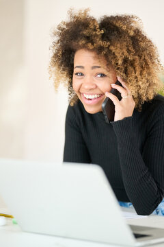 Happy freelancer talking on phone with smile.
