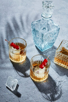 Two Whiskey Tonics with Maraschino Cherry Garnish and Bottles 