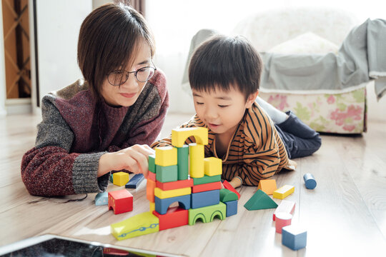 Mother and boy playing blocks at home