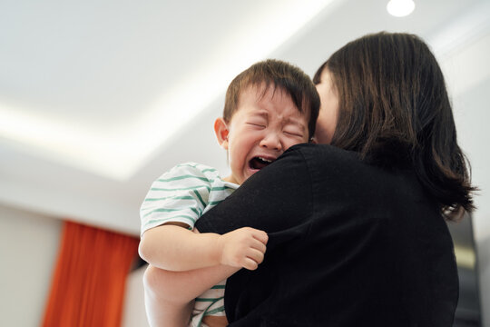 Mother holding crying little boy