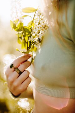 Anonymous woman with flowers in sunlight