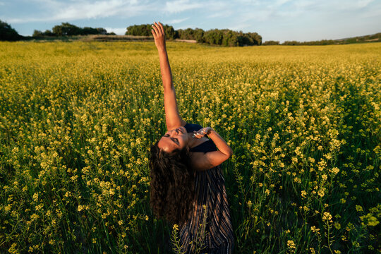 Hispanic woman dancing among flowers