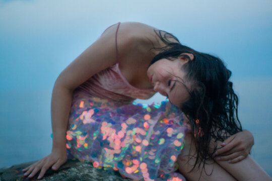 Young brunette woman in glittering dress outdoors