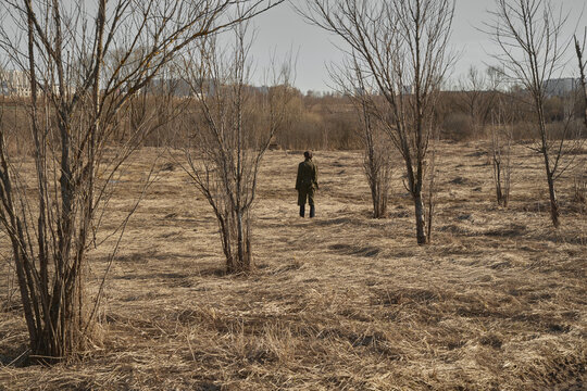 Lonely person amidst leafless trees