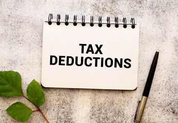 white paper with text Tax Deductions on a yellow background with stationery