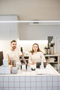Young team of baristas in a coffee shop look at the camera 