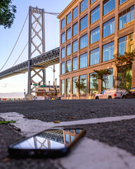bay bridge reflection on smart phone in the city
