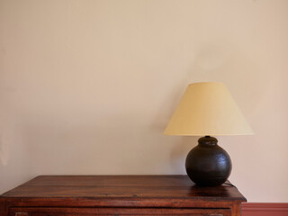 Home decoration with vintage lamp and furniture, warm plain wall.