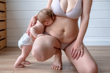 infant kisses mother stretch marks belly