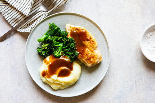 Plate of food with gravy chicken and veg