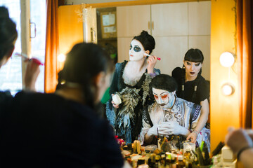 Actors  in front of a mirror make make-up themself