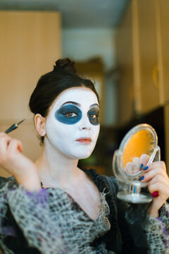 An actress  with small mirror makes her make-up